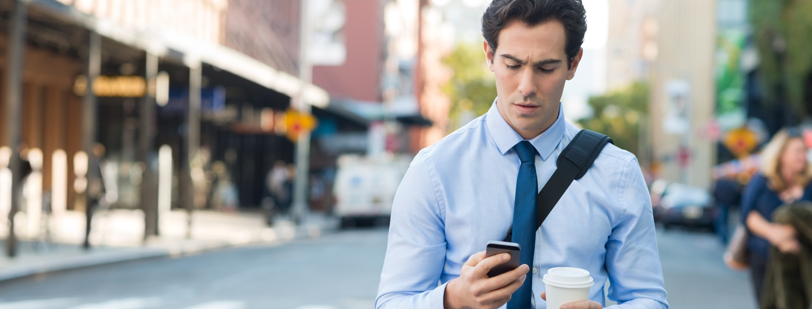 Younger male business person looking at his cell phone concerned