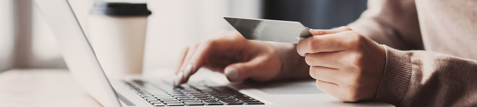 Woman using credit card at computer